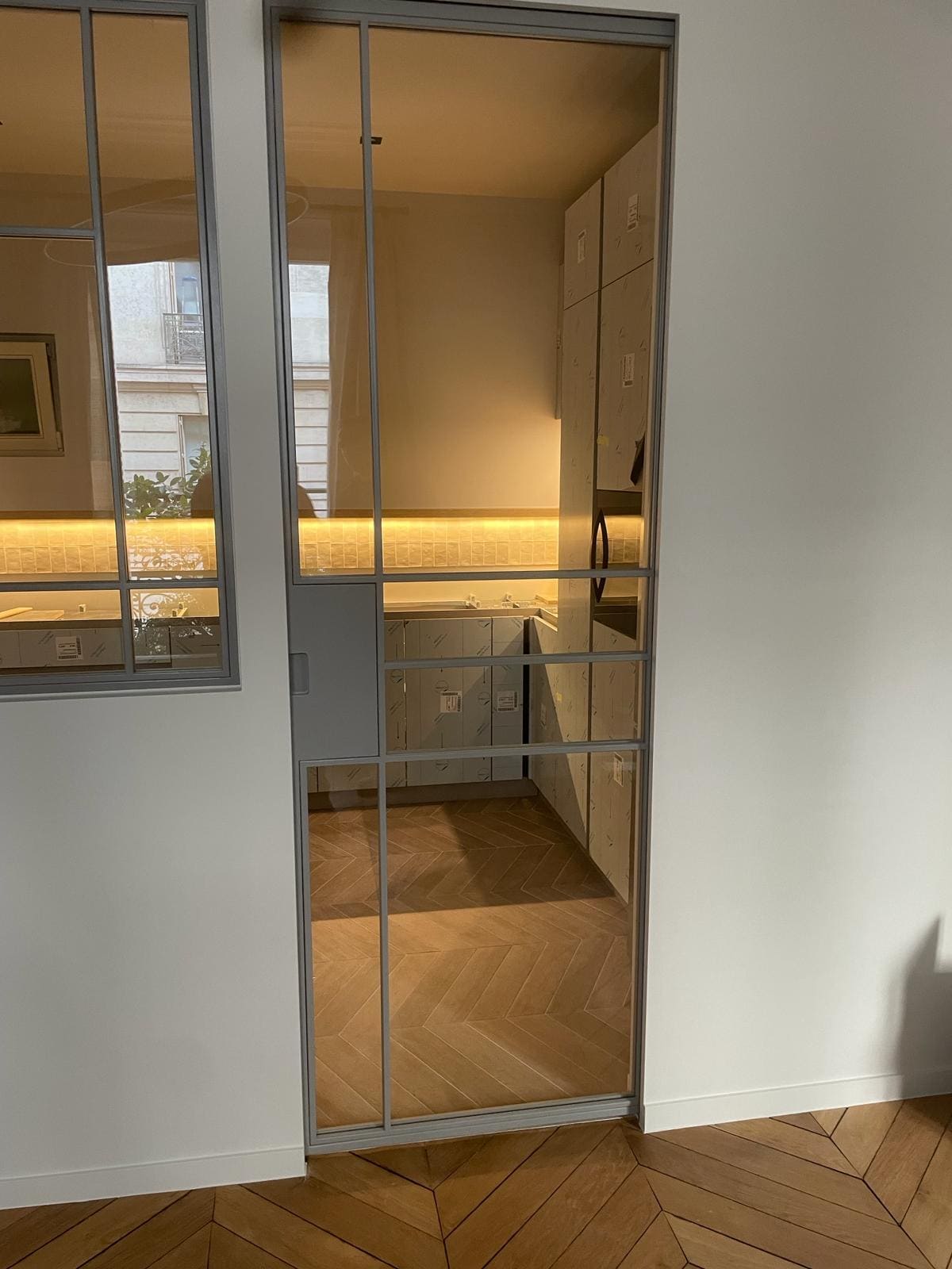 Une porte vitrée qui donne la vue sur une cuisine