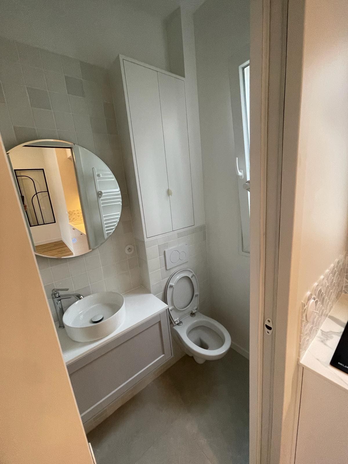 Des toilettes avec un wc, un lavabo, des tiroirs et du carrelage