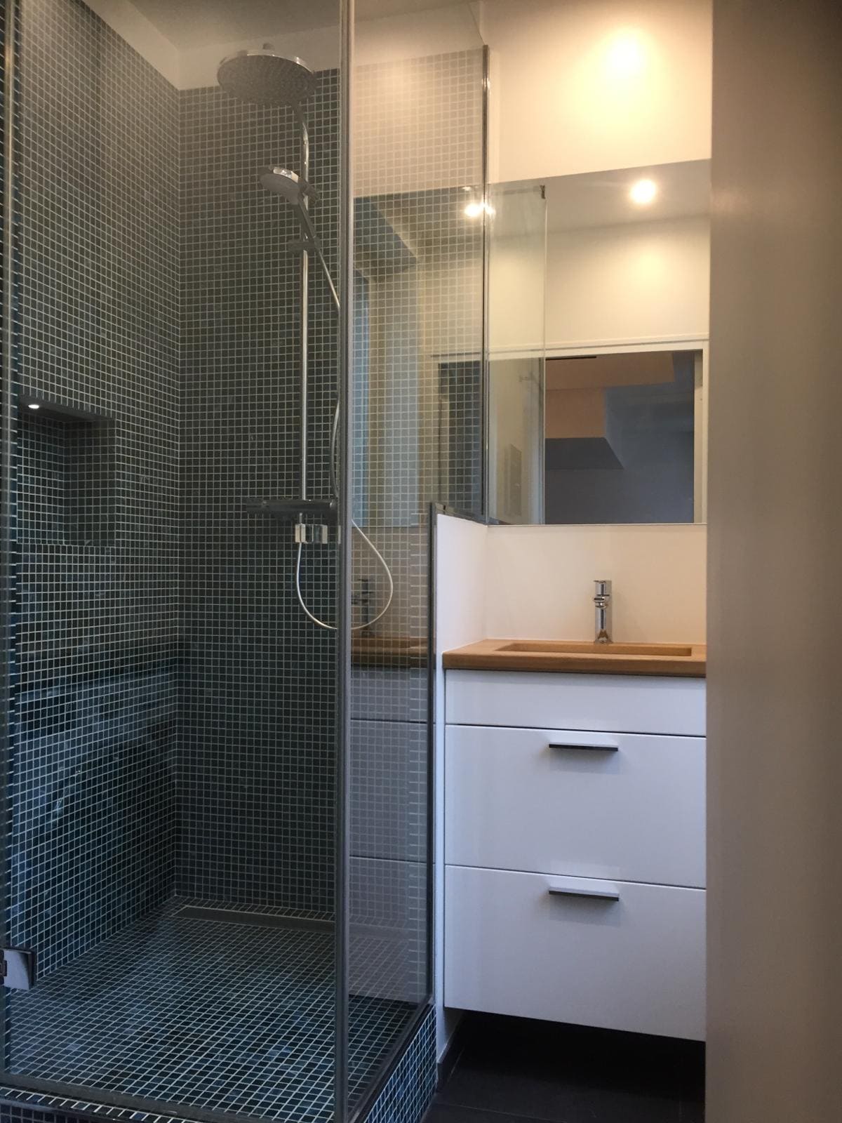 Une douche avec une lavabo et du carrelage vert