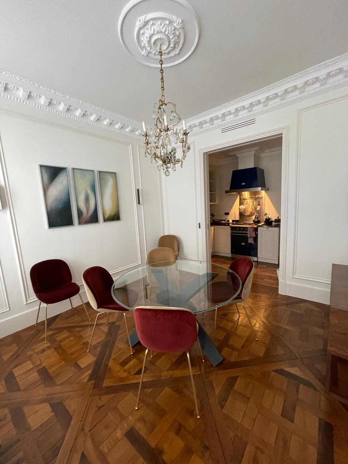 Un salon avec une table en verre et des chaises rouges