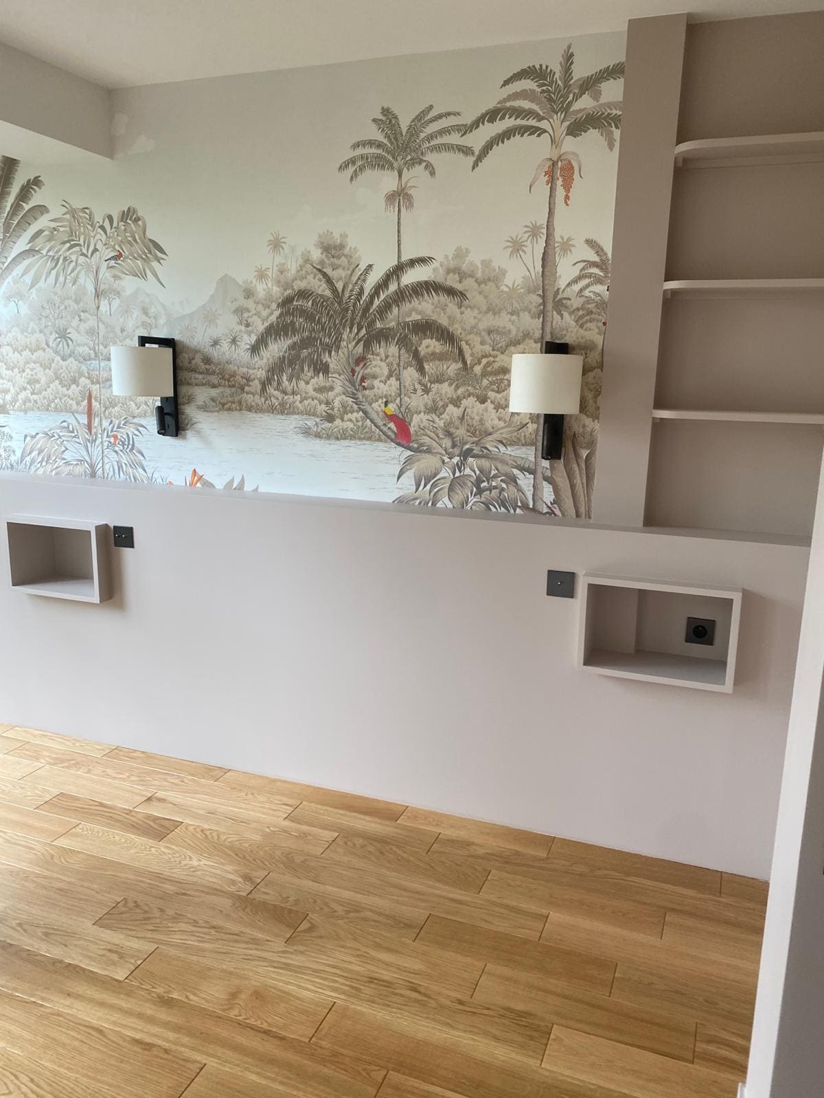 Une chambre vide avec une tapisserie représentant une forêt tropicale