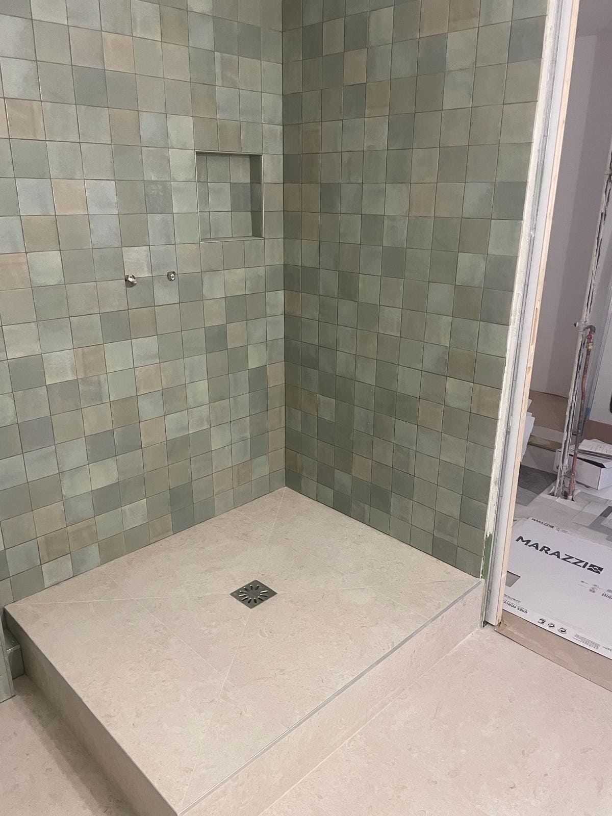 Une douche avec dy carrelage vert