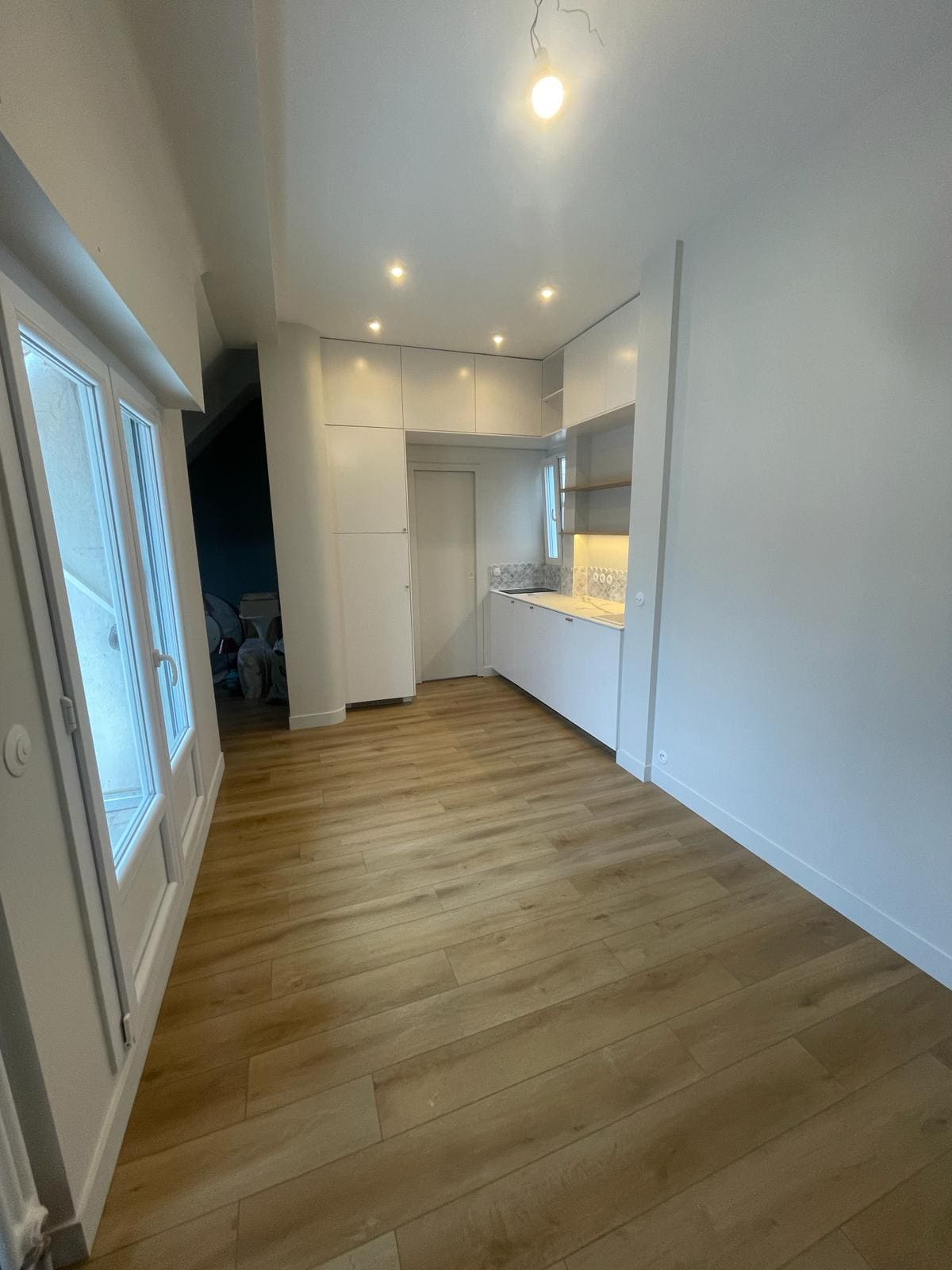 Une cuisine blanche avec un parquet